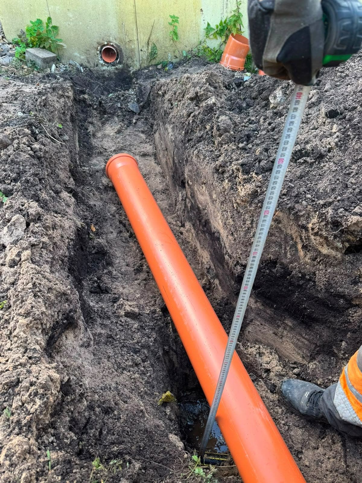 Kanalizācijas caurules dziļuma mērīšana tranšejā